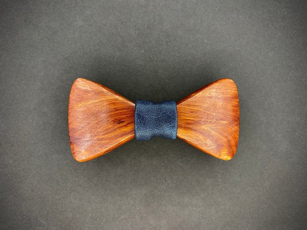 Cedar wooden bowtie with a dark blue leather middle wrap.